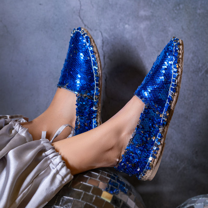 A foot of lady wearing a Sitara Espadrilles blue, ladies shoe kept upon a glittery ball.