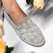 Load image into Gallery viewer, A foot of lady who have worn a Kaira Silver Espadrilles ladies shoes kept upon a white background with some roses aside..