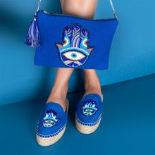 Load image into Gallery viewer, A women posing with beautiful Hamsa Bag Blue handbags for women and with matching pair of shoes.