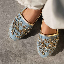 Load image into Gallery viewer, woman's feet in blue Espadrilles with a small embroidery of gold detailing on them with a pattern around the bottom and sides