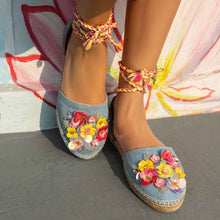Load image into Gallery viewer, a woman with sequinized feet standing on a floor wearing blue carnation Tie-up Espadrilles, featuring colorful flowers and straps that wrap around the ankle