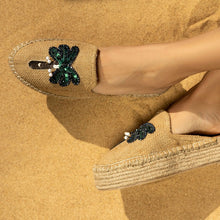 Load image into Gallery viewer, A model's cross legged feet wearing Coco Beige Espadrilles Platforms with palm tree design featuring footwear for women kept on a beige background