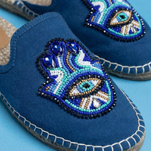 Load image into Gallery viewer, a pair of Hamsa Blue espadrilles flats having evil eye protector design kept against a light blue background