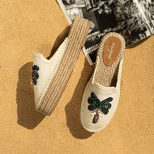 Load image into Gallery viewer, A pair of coco off-white espadrilles platform with a green palm tree on top of it lying on a light brown ground