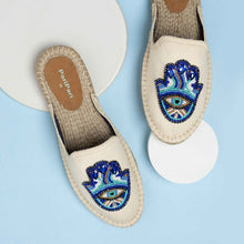 Load image into Gallery viewer, a pair of Hamsa off-white espadrilles flats having evil eye protector design on a blue and white background