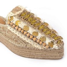 Load image into Gallery viewer, A single photo of golden Espadrilles with a small detailing on them with a pattern around the bottom and sides on a white background.