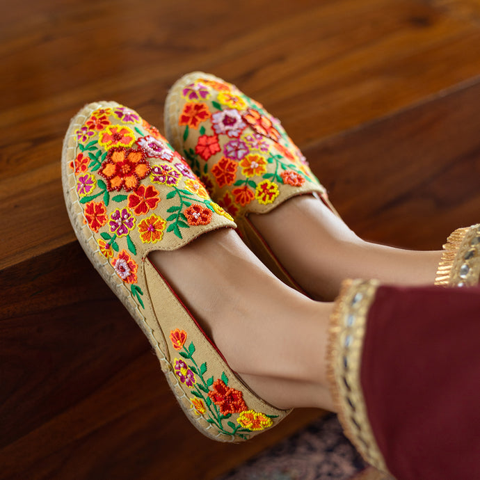 A woman has worn beautiful Bageecha Beige Espadrilles footwear for women supported on a wooden table.