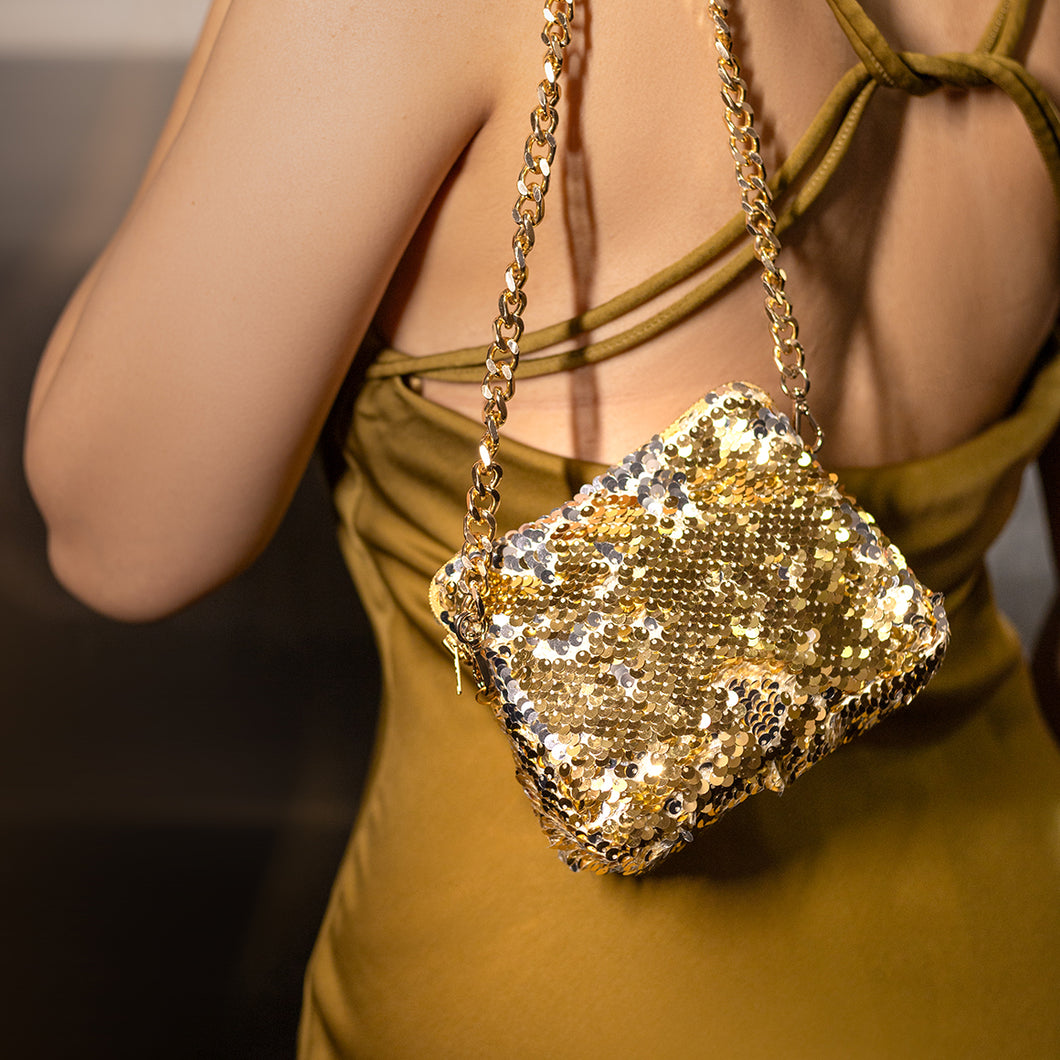 A woman wearing beautiful and shimmery Sitara micro bag gold.