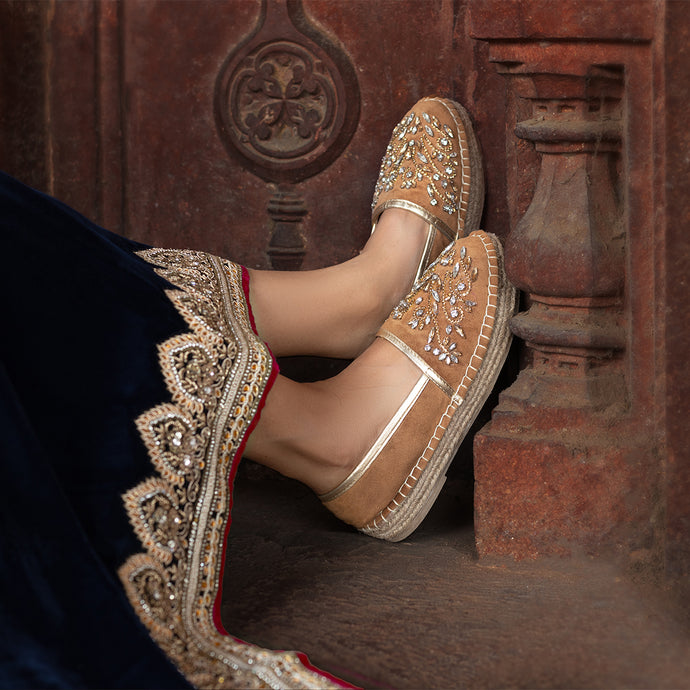 A woman has worn beautiful Diva Gold Espadrilles shoes for women, leaning on a old wall. 
