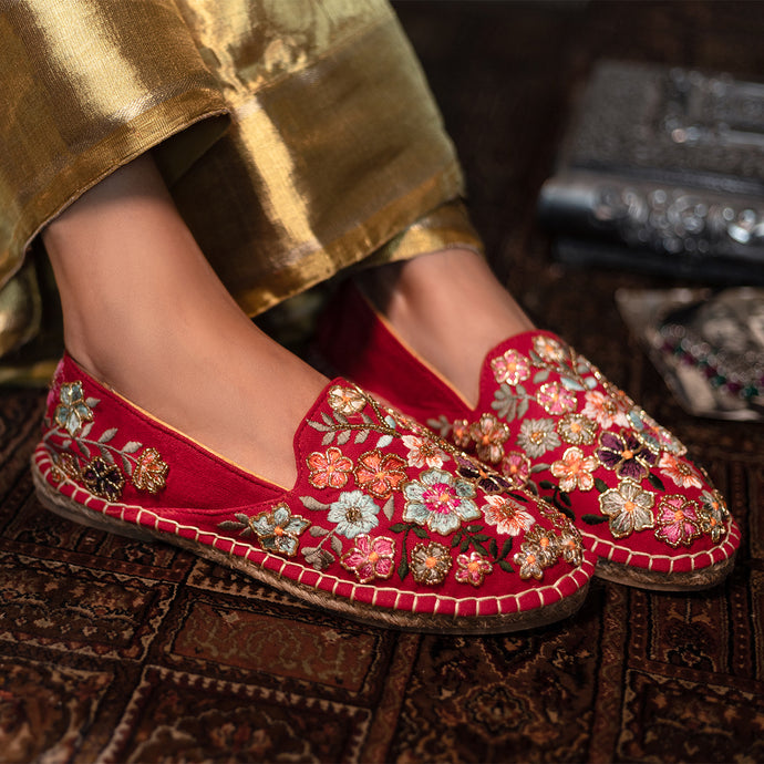 A woman has worn beautiful Bageecha Red Espadrilles footwear for women, kept upon a mat.