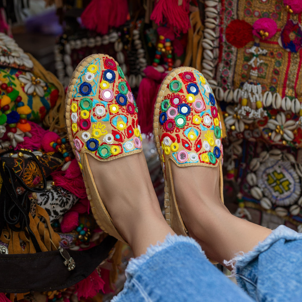 A foot of lady who have worn a Nomad Espadrilles Beige footwear for women kept upon a colorful cloth.