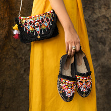 Load image into Gallery viewer, A women posing by wearing beautiful Masai Bag Black handbags for women with its matching shoes.
