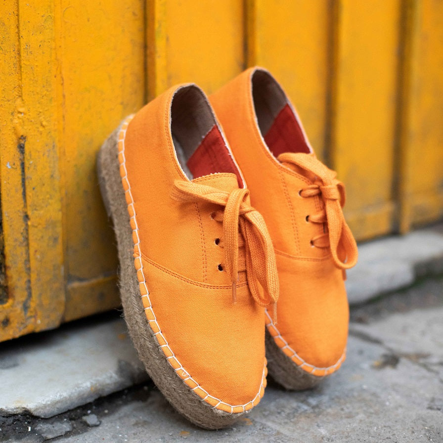 Image of the The Walking Havana Lace-ups - Tangy Orange  Shoes for women against a street background