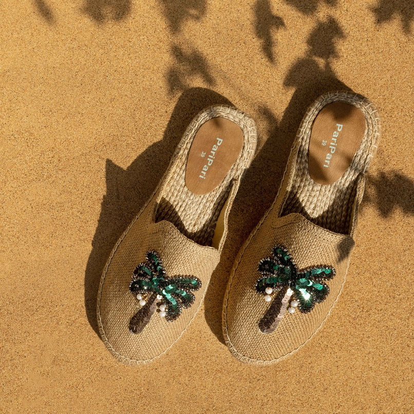 A pair of Coco Beige Espadrilles with palm tree design featuring juttis for women kept on a beige background