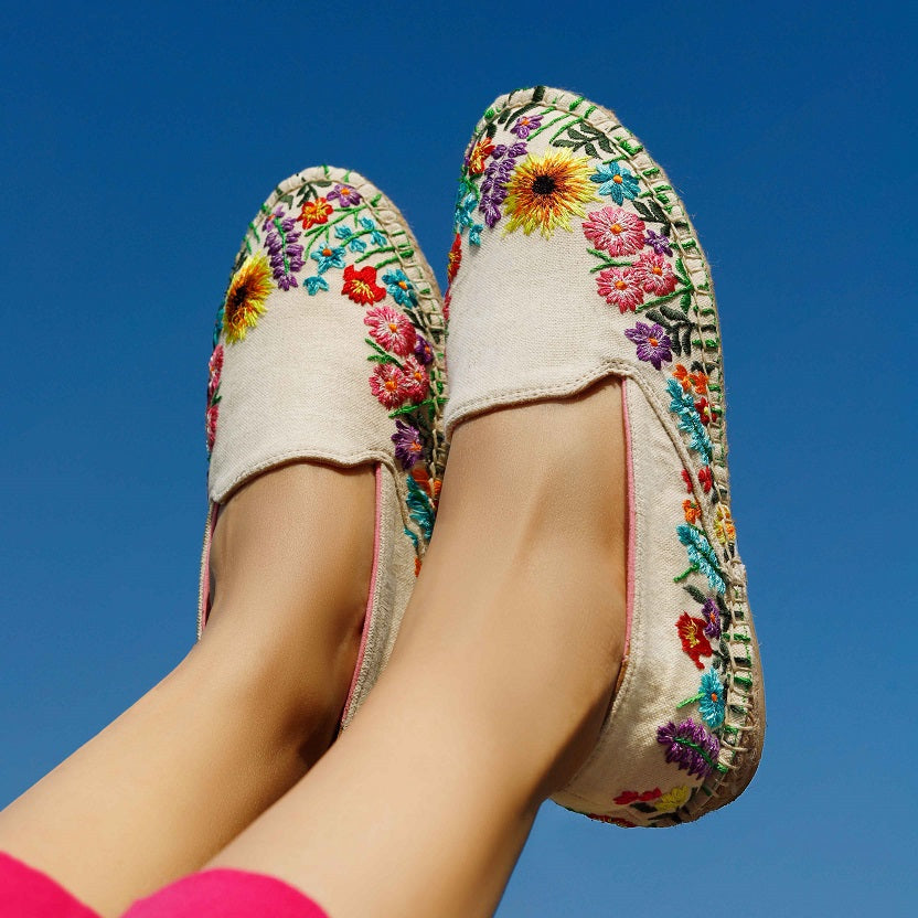 Women's leg in colorful embroidered Espadrilles, posing towards the sky.