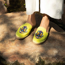 Load image into Gallery viewer, woman wearing a pair of Hamsa green espadrilles flats having evil eye protector design, standing on a rock.
