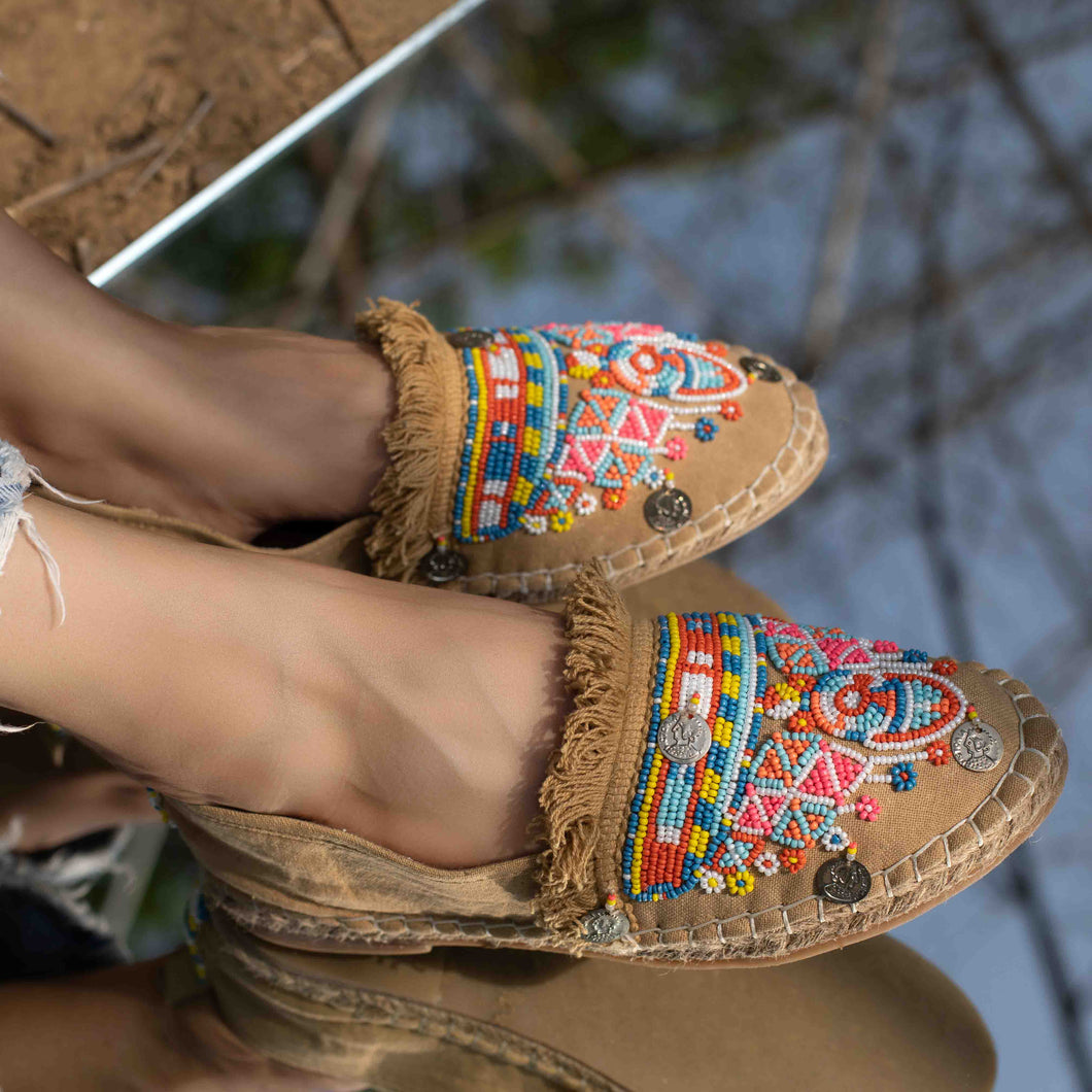 A feet of a model wearing beautiful Masai Beaded Espadrilles Beige showcasing juttis for women