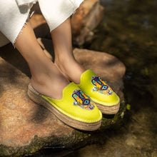 Load image into Gallery viewer, woman wearing a pair of Hamsa green espadrilles platform having evil eye protector design, sitting on a rock.
