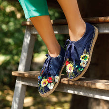 Load image into Gallery viewer, a girl standing on a wooden stair wearing a pair of blue espadrilles decorated with colorful flowers
