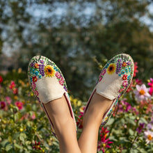 Load image into Gallery viewer, Women&#39;s leg with crossed feet in colorful embroidered Espadrilles in front of bushes of flowers.
