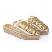 Load image into Gallery viewer, A pair of golden Espadrilles with a small detailing on them with a pattern around the bottom and sides on a white background.
